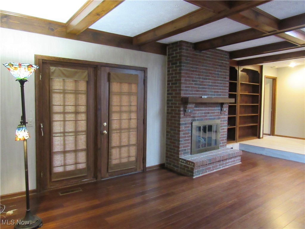 1120 Vincent Road Southeast North Canton, OH 44720 - Photo 20 of 50 Great Room featuring a fireplace, dark hardwood / wood-style floors, coffered ceiling, beam ceiling and double doors leading to Sunporch