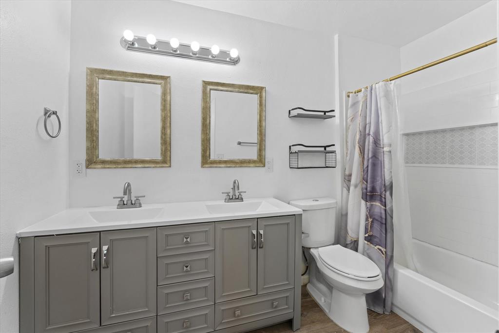 9521 Dalrock Road Rowlett, TX 75089 - Photo 22 of 38 a bathroom with a toilet a sink a mirror a shower a vanity and window