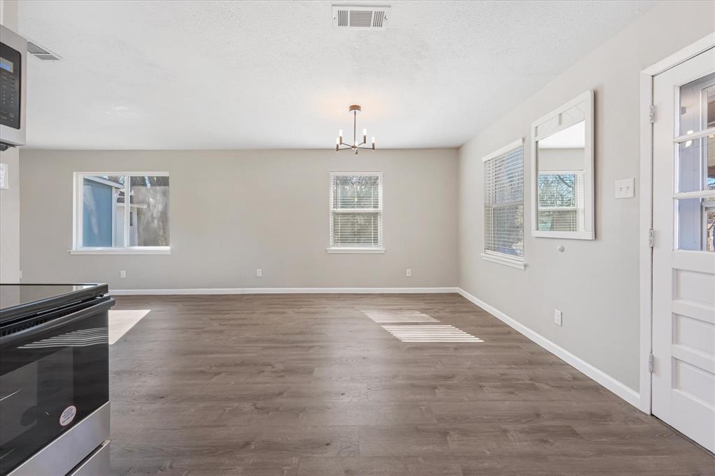 9521 Dalrock Road Rowlett, TX 75089 - Photo 8 of 38 an empty room with windows and cabinet