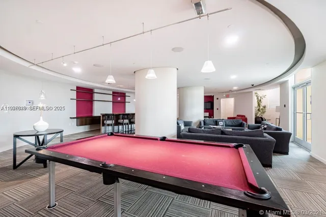 a room with pool table and windows