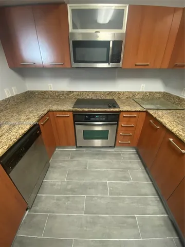 a kitchen with granite countertop a stove and a sink