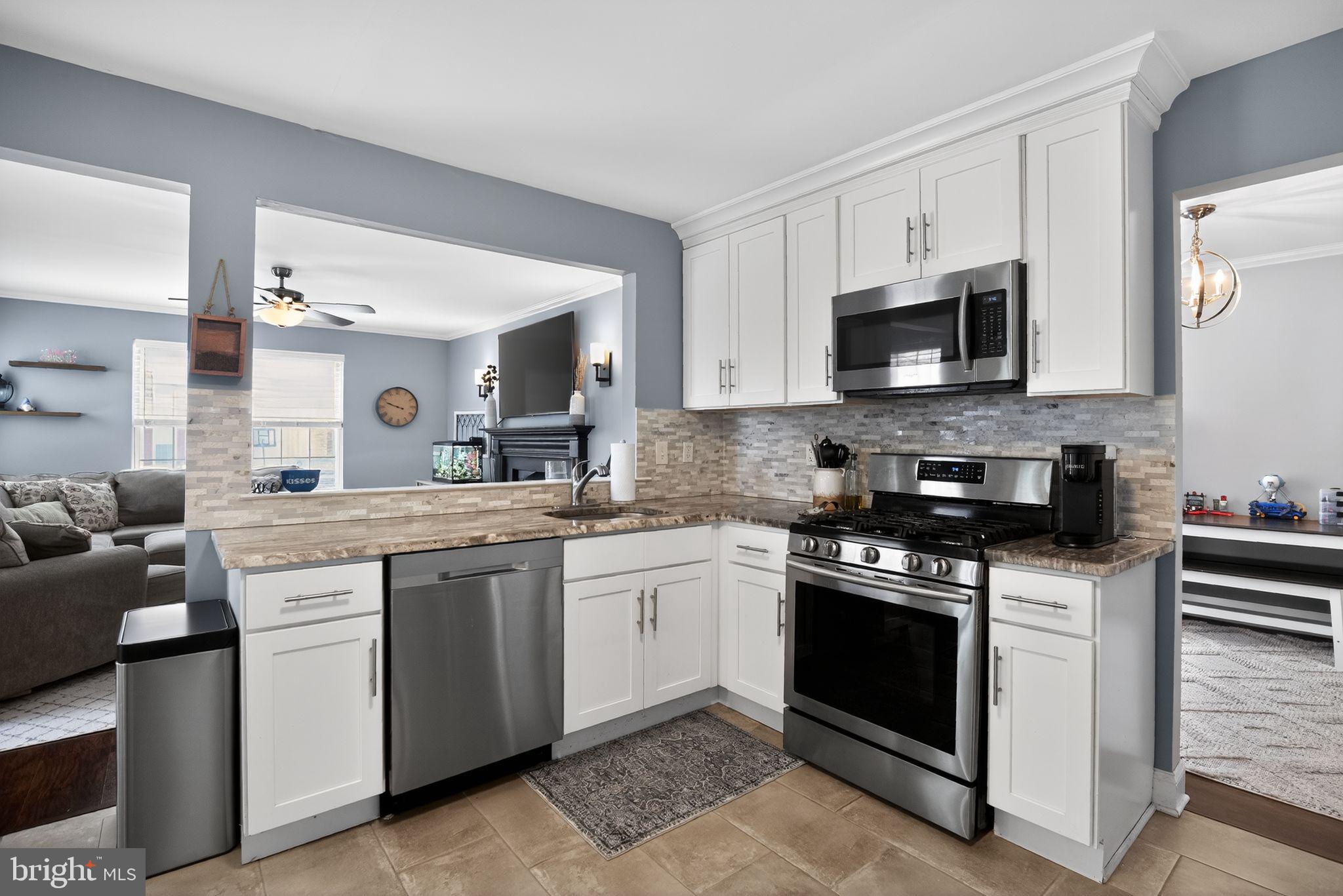 9 Bromley Court Atco, NJ 08004 - Photo 16 of 36 a kitchen with stainless steel appliances granite countertop a stove top oven a sink dishwasher and white cabinets with wooden floor