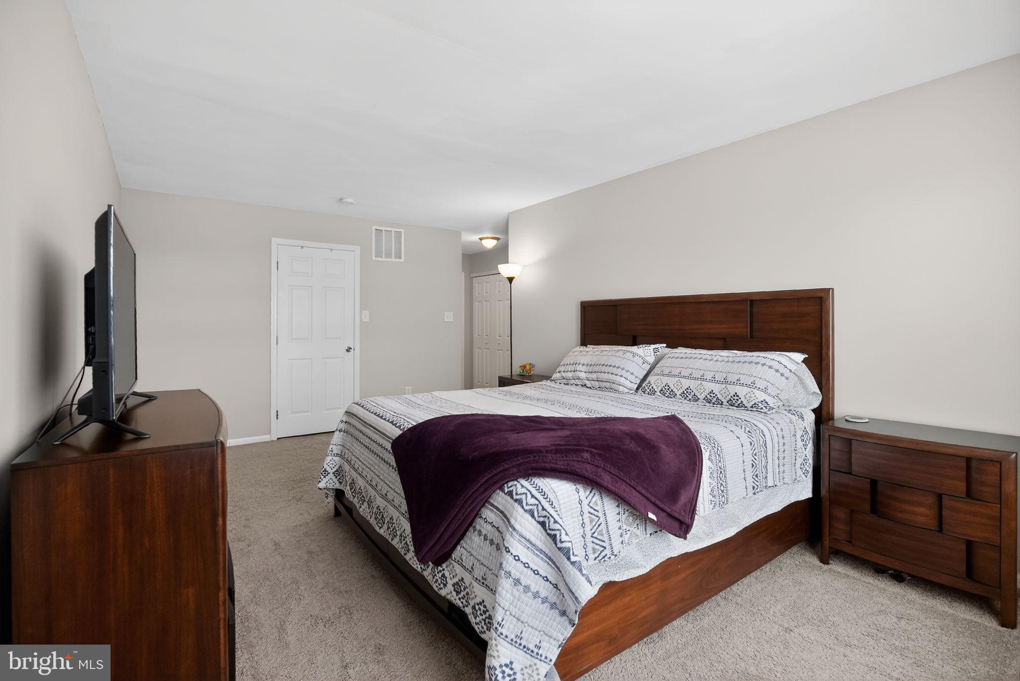 9 Bromley Court Atco, NJ 08004 - Photo 30 of 36 a bedroom with a bed and flat tv screen on a dresser