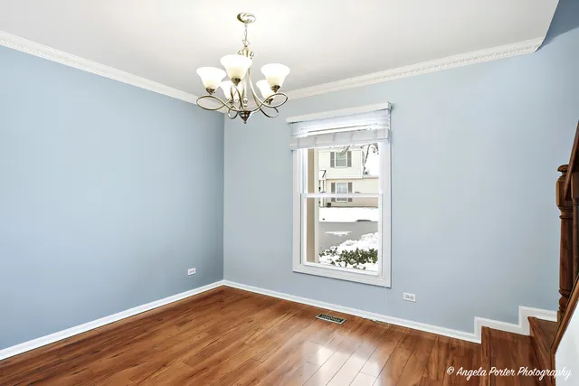 a view of a room with wooden floor and chandelier