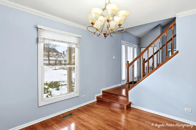 a view of an entryway with wooden floor and chandelier