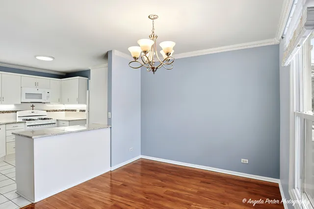 a view of a kitchen with a sink a chandelier and refrigerator