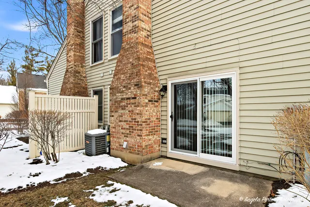 a view of a brick house with a yard and large tree