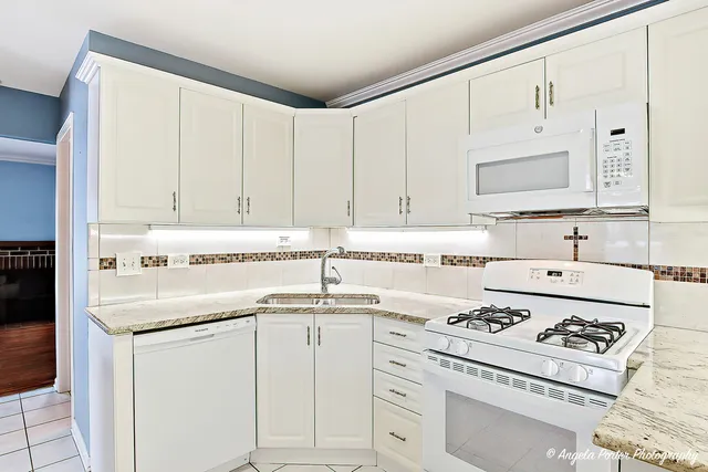 a kitchen with cabinets appliances a sink and a stove