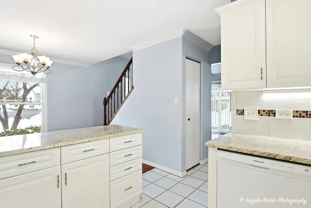 a kitchen with granite countertop white cabinets and white appliances