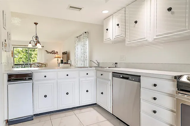 a kitchen with granite countertop white cabinets and white appliances