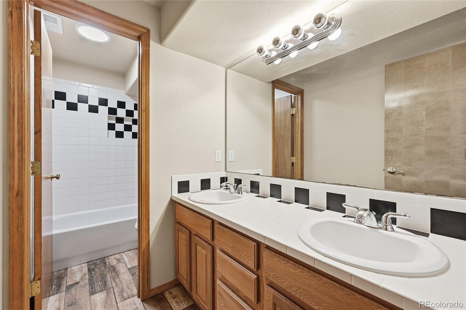 9288 Rockingham Drive Peyton, CO 80831 - Photo 31 of 49 a bathroom with a sink double vanity and a mirror