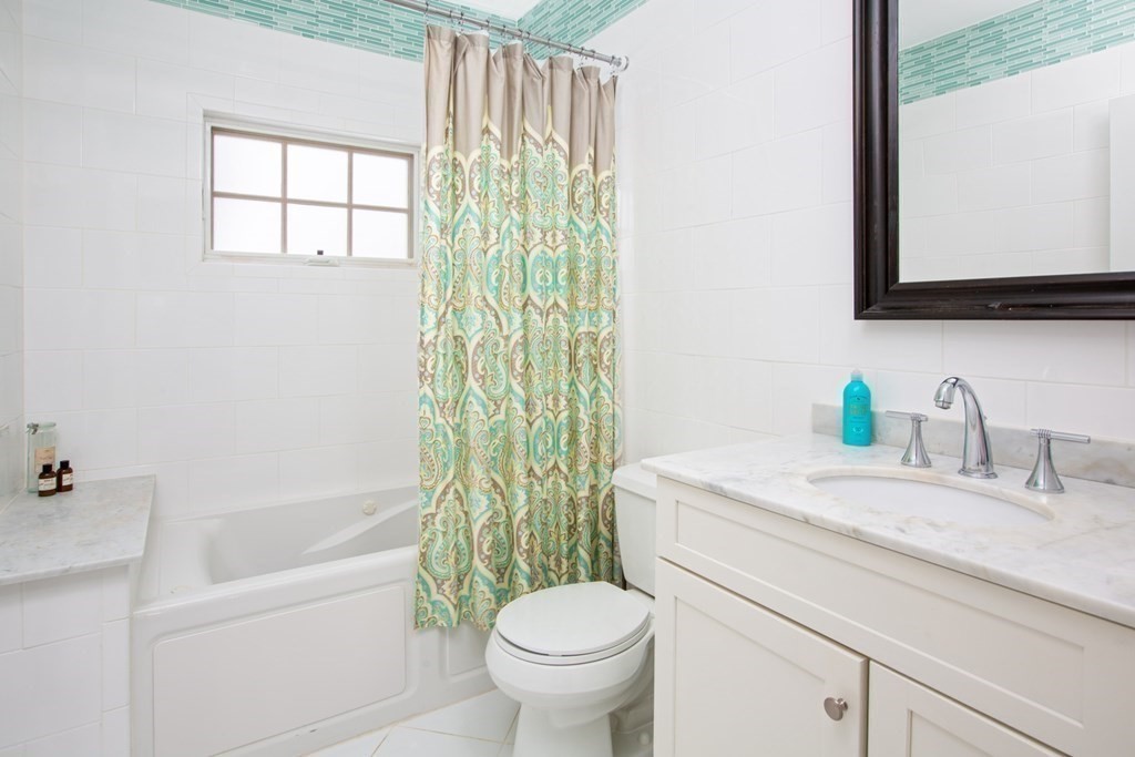 14 Castleton Street, Unit 2 Boston, MA 02130 - Photo 11 of 23 a bathroom with a granite countertop sink toilet and mirror