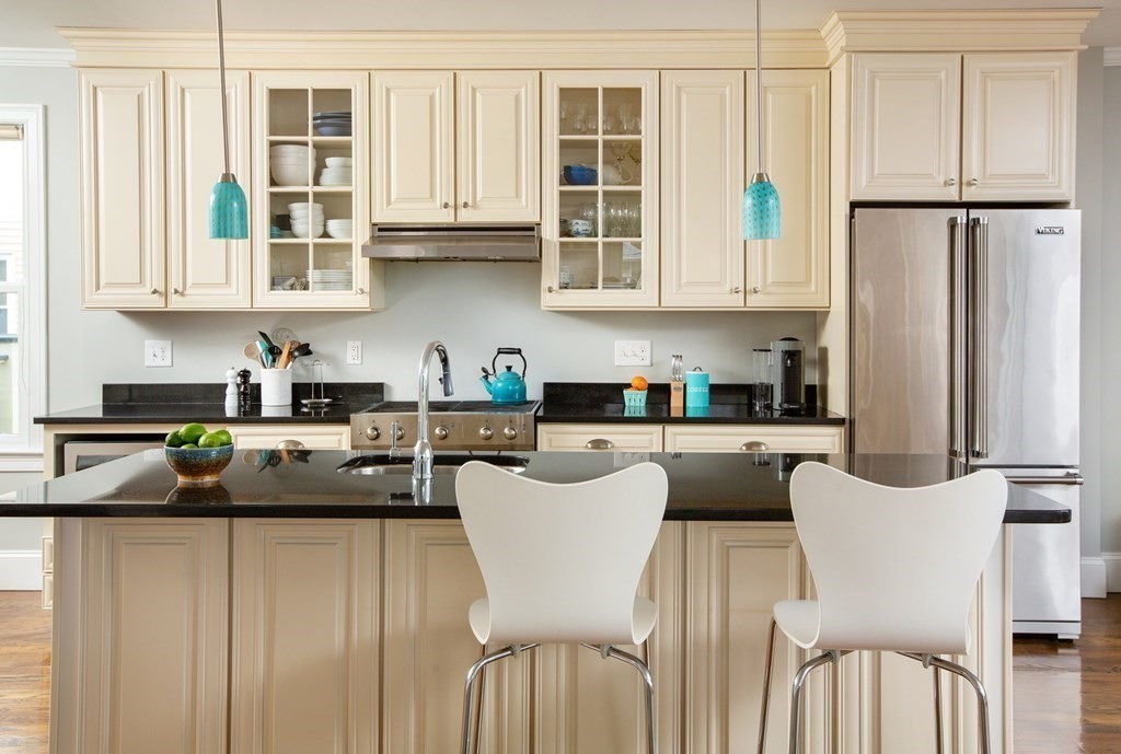 14 Castleton Street, Unit 2 Boston, MA 02130 - Photo 5 of 23 a kitchen with stainless steel appliances granite countertop a refrigerator a sink dishwasher a dining table and chairs with wooden floor