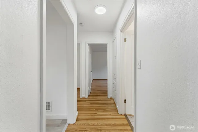 a view of a hallway with wooden floor and staircase