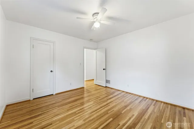 a view of an empty room with wooden floor