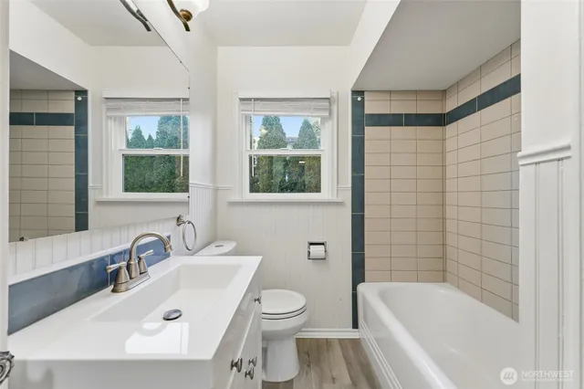 a bathroom with a sink a toilet a mirror a bathtub and shower