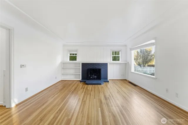 a view of an empty room with a fireplace and a window