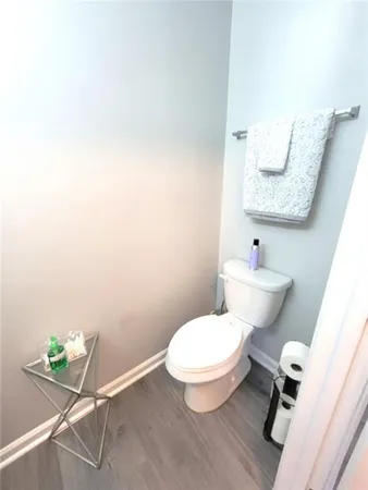 a white toilet sitting next to a bathroom sink and a mirror