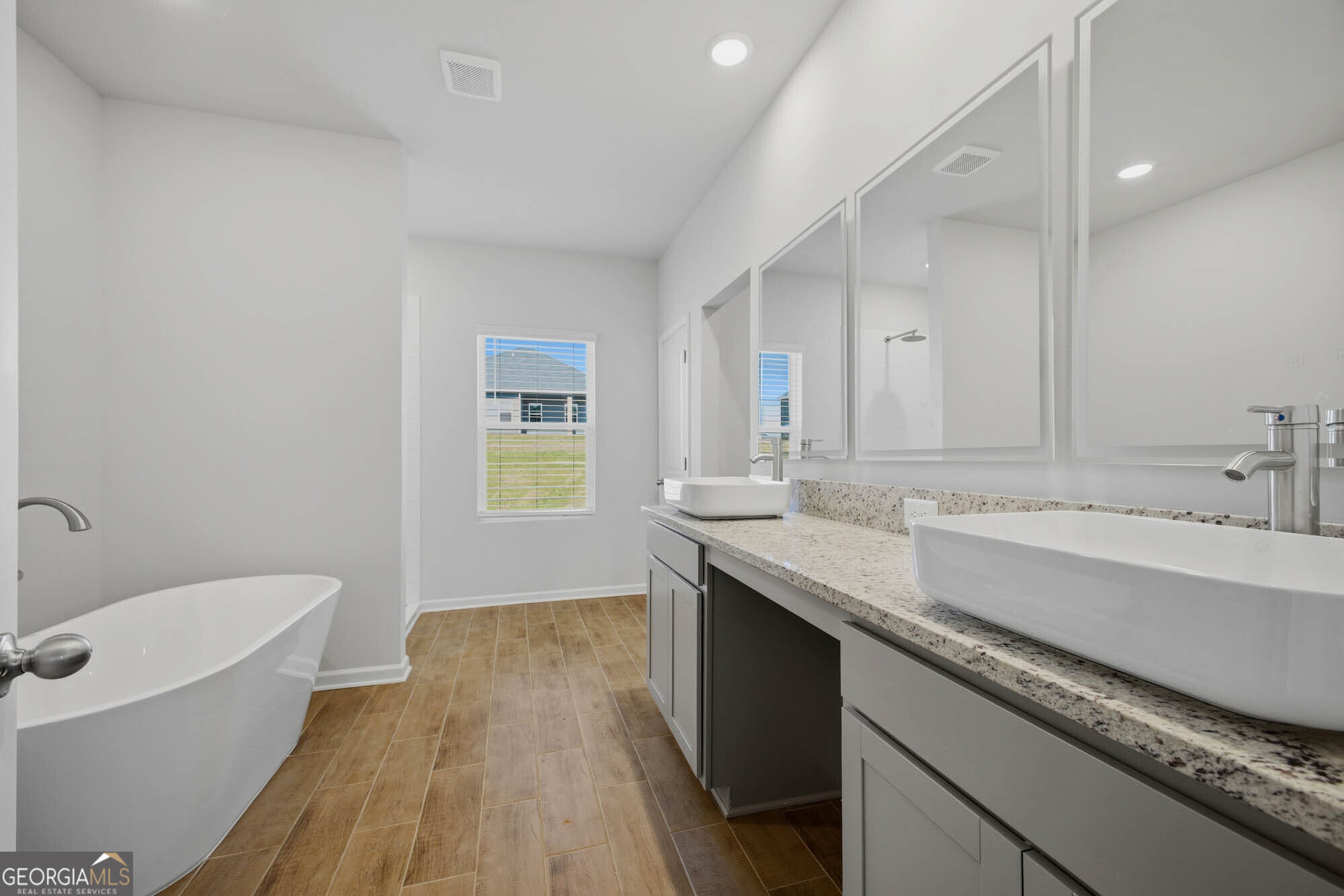 309 Rusty Plow Lane Perry, GA 31069 - Photo 5 of 34 a bathroom with a granite countertop double vanity sink a mirror and a bathtub
