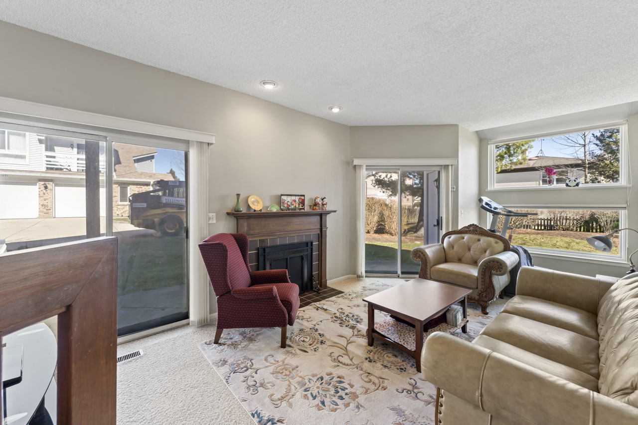 1265 Ranchview Court Buffalo Grove, IL 60089 - Photo 4 of 24 a living room with furniture a large window and a fireplace