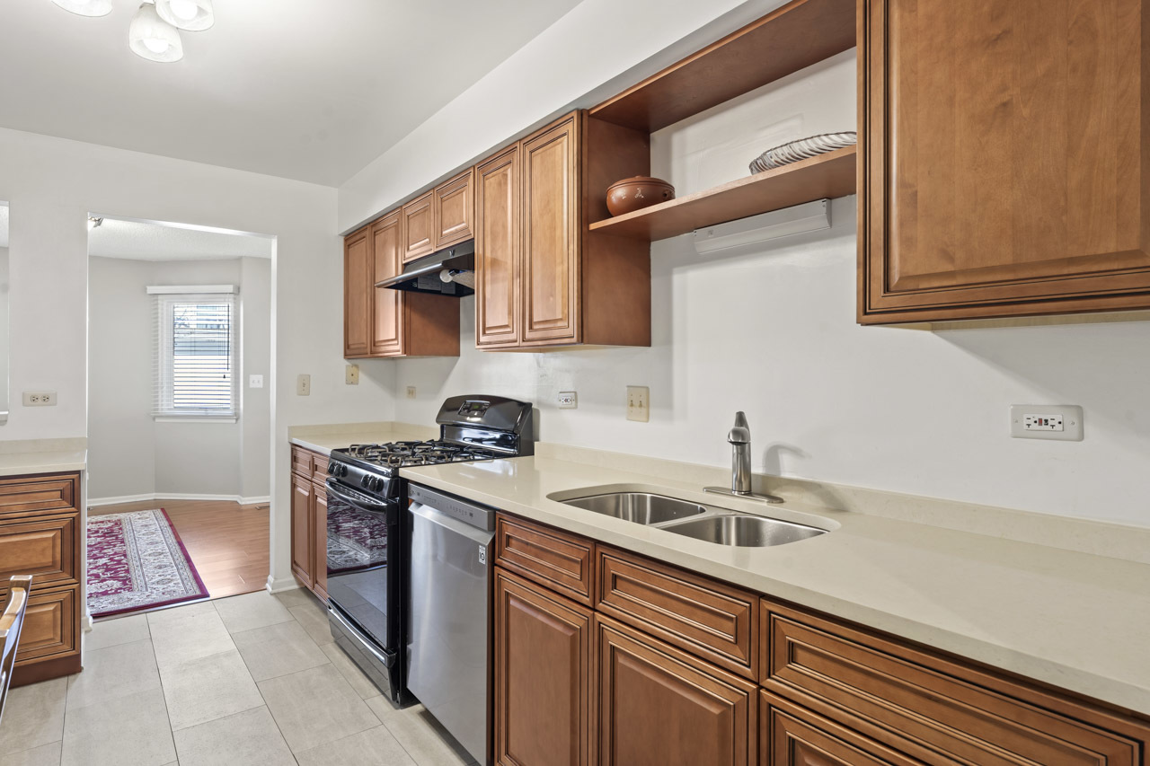 1265 Ranchview Court Buffalo Grove, IL 60089 - Photo 10 of 24 a kitchen with stainless steel appliances granite countertop a sink stove and cabinets