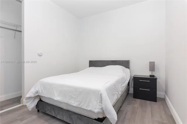 a bedroom with a bed and a night stand