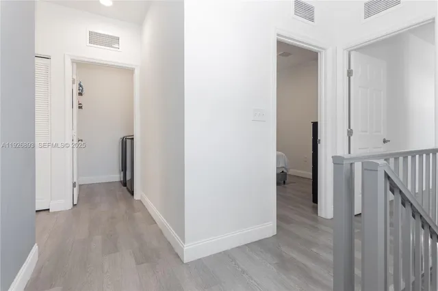 a view of a hallway with wooden floor and entryway