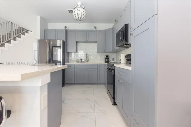 a kitchen with stainless steel appliances a sink stove and cabinets