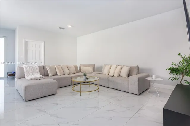 a living room with furniture and a potted plant