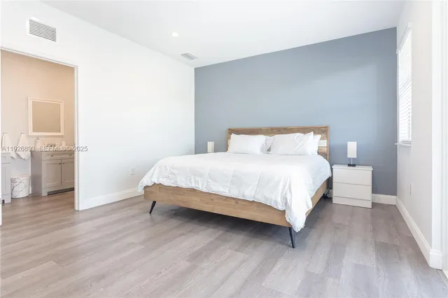 a bedroom with a bed and wooden floor