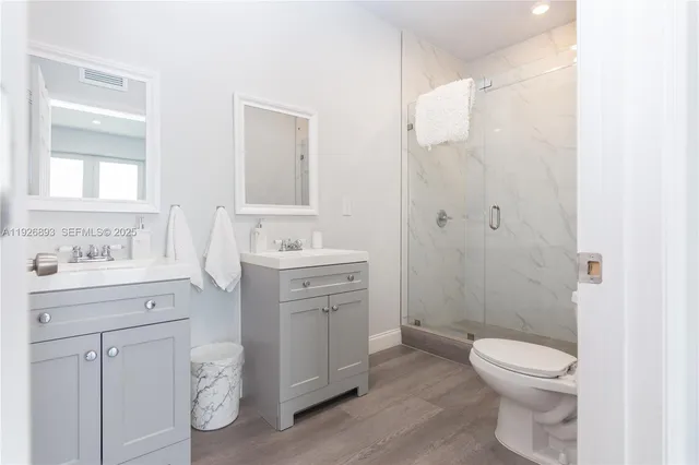 a bathroom with a toilet a sink a vanity and windows