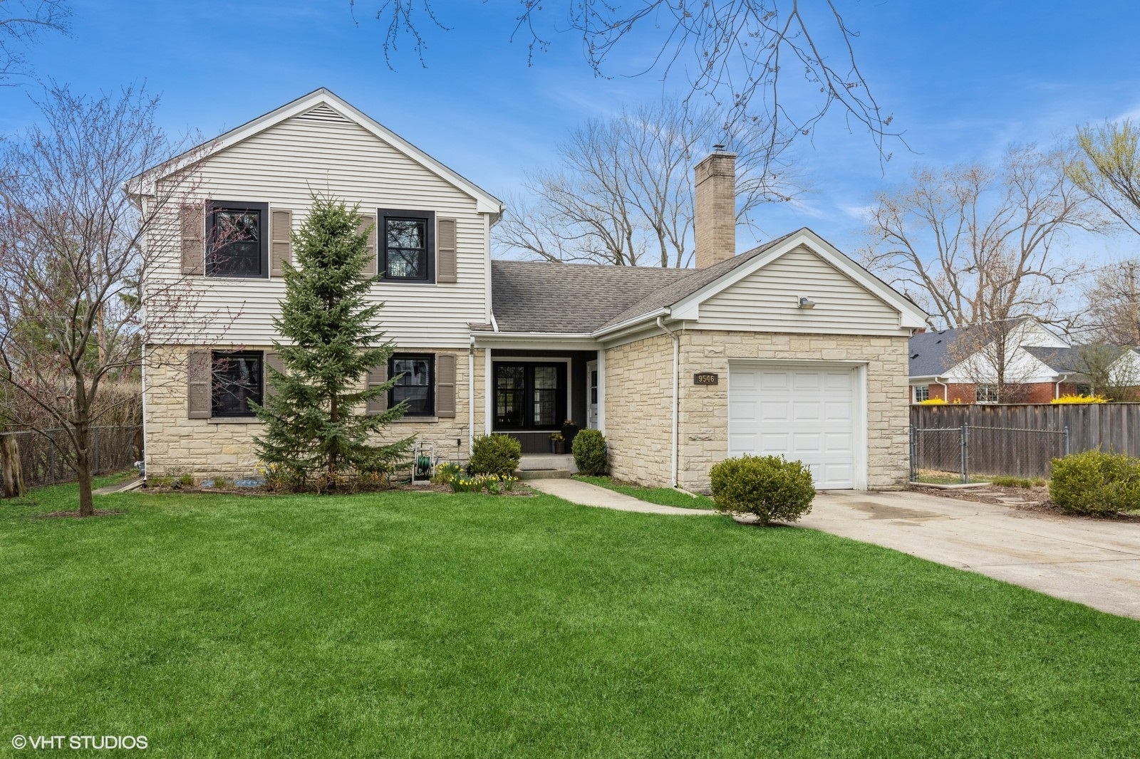 a front view of a house with a yard and trees