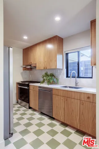 a kitchen with stainless steel appliances granite countertop a stove a sink and a microwave