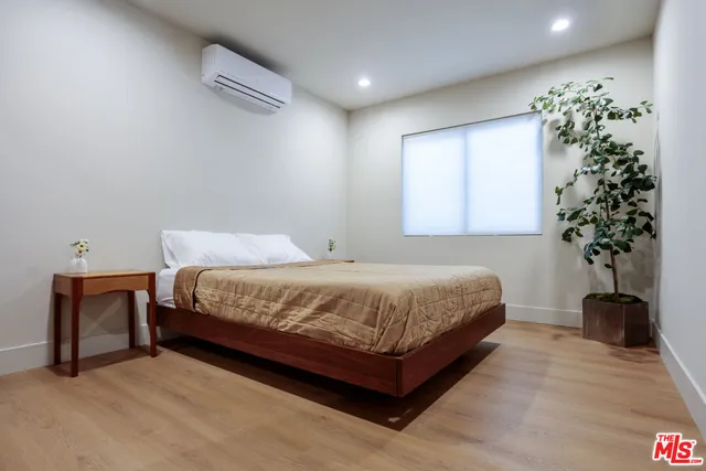 a bedroom with a bed and a potted plant