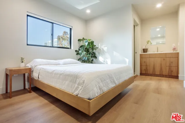 a large bed sitting in a spacious bedroom next to a bathroom