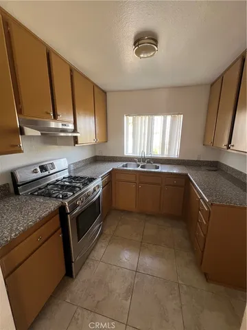 a kitchen with a stove sink and cabinets