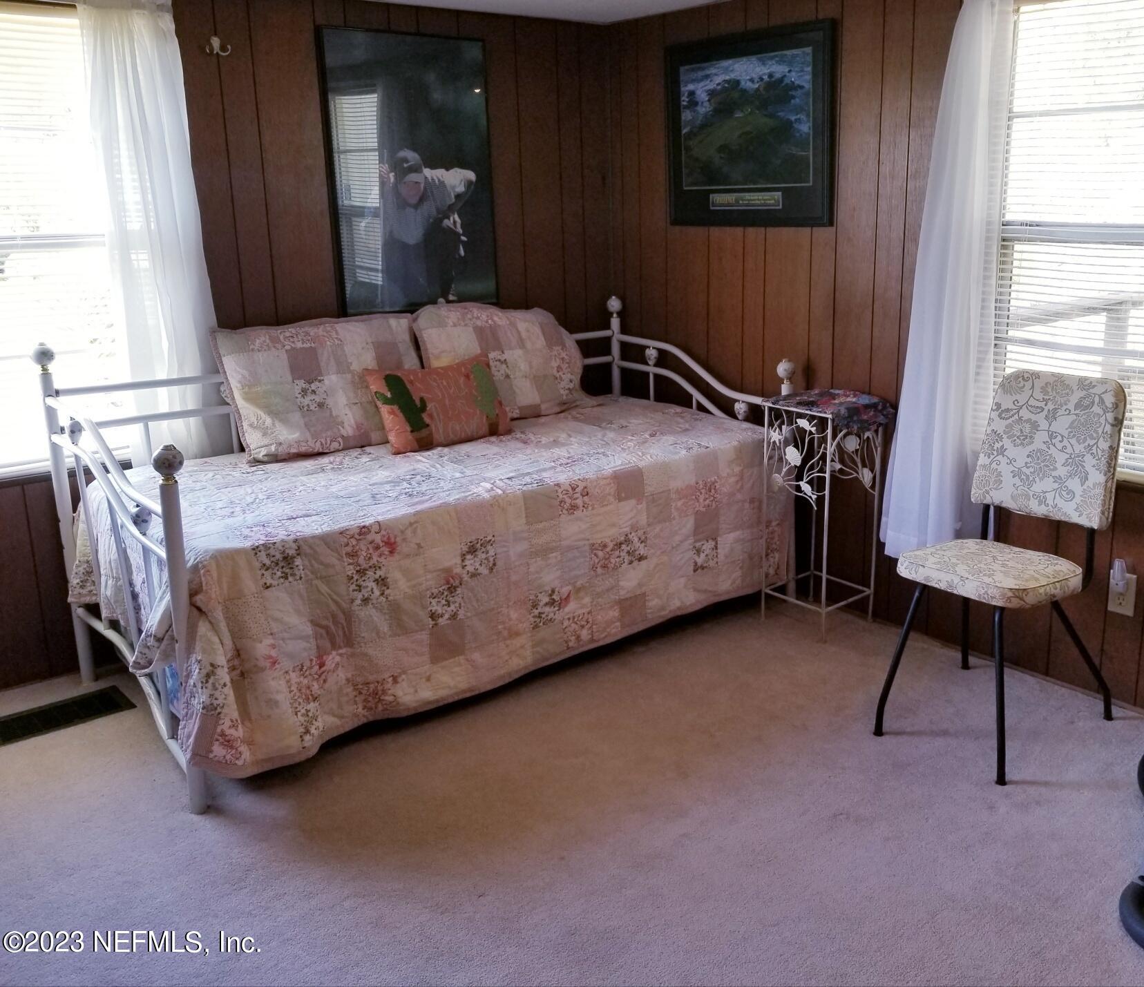 116 Douglas Street Crescent City, FL 32112 - Photo 13 of 26 a bedroom with a bed a chair and a window