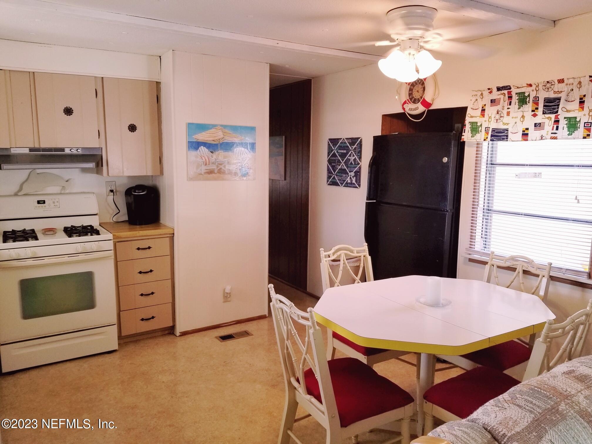 116 Douglas Street Crescent City, FL 32112 - Photo 6 of 26 a kitchen with stainless steel appliances a stove a refrigerator a dining table and chairs