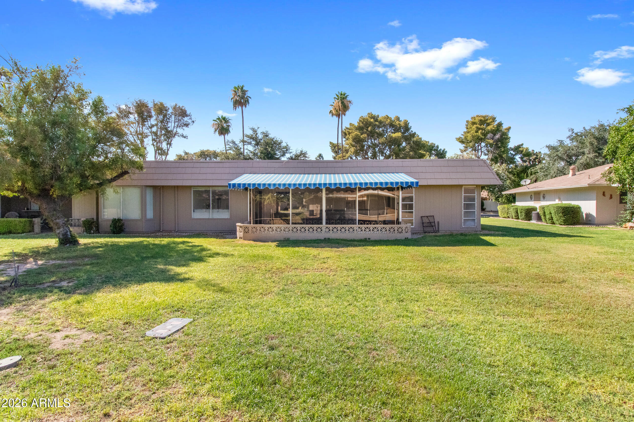 9801 West Pleasant Valley Road Sun City, AZ 85351 - Photo 23 of 26 a front view of a house with a yard table and chairs