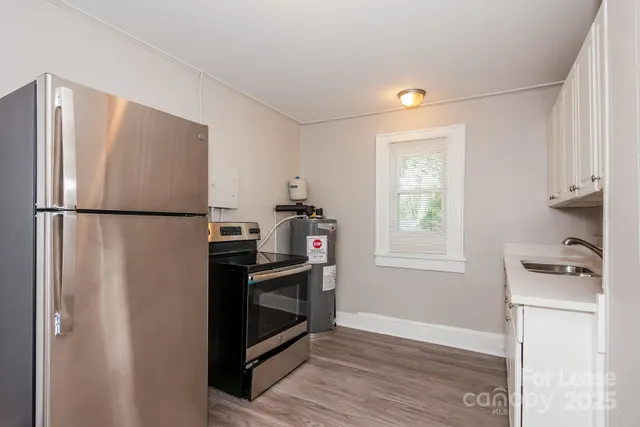 a kitchen with stainless steel appliances granite countertop a refrigerator and a stove top oven