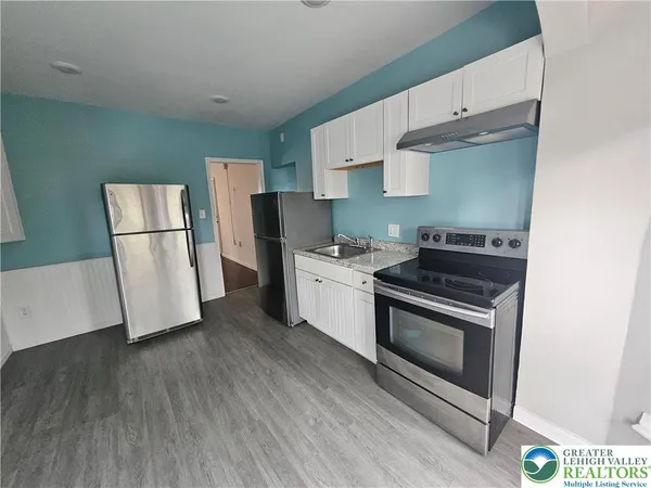 a kitchen with a stove a microwave and a refrigerator