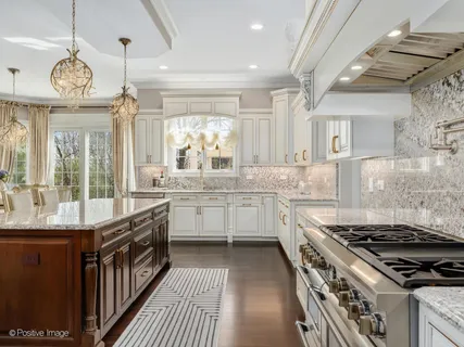 a kitchen with stainless steel appliances granite countertop a sink a stove and a wooden floors