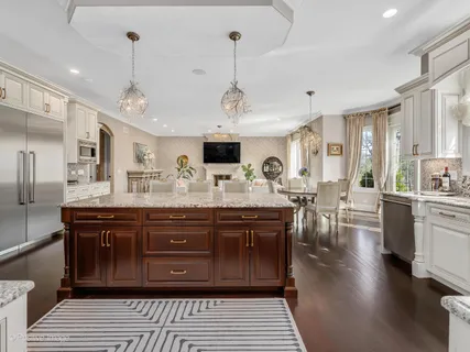 a large kitchen with lots of counter space a sink dishwasher a dining table and chairs