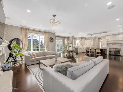 a living room with furniture kitchen view and a large window