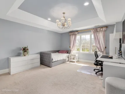 a spacious bedroom with a bed and a table chair