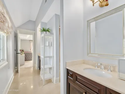 a en suite bathroom with a granite countertop sink and a mirror