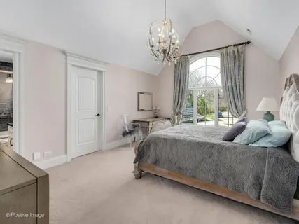 a spacious bedroom with a bed and a chandelier