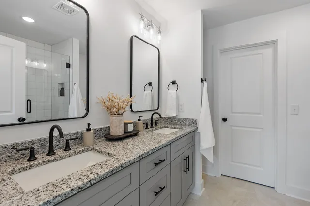 a bathroom with double vanity sinks and a mirror