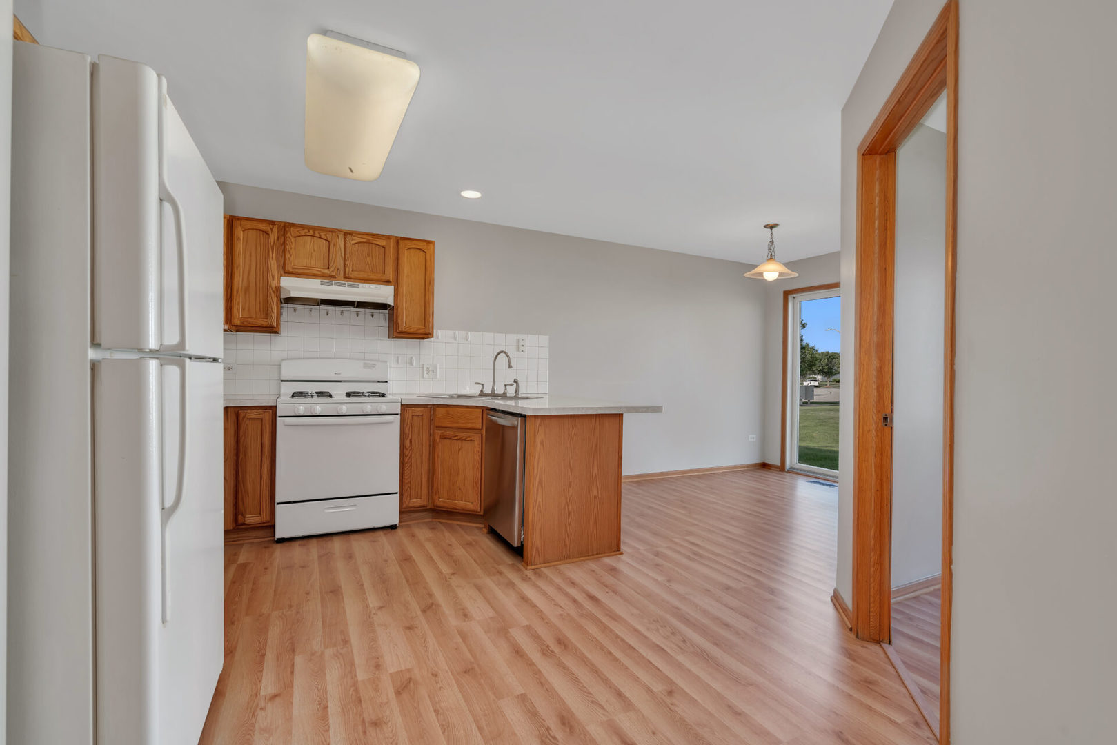 1747 Waters Edge Drive Minooka, IL 60447 - Photo 5 of 11 a kitchen with stainless steel appliances a white stove top oven and a refrigerator