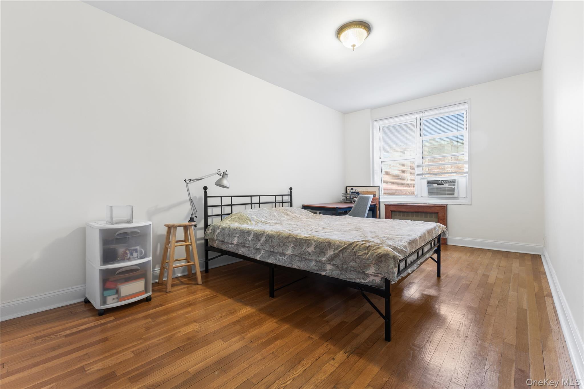 64-11 99th Street, Unit 3O4 Queens, NY 11374 - Photo 14 of 23 Bedroom featuring hardwood / wood-style floors and radiator heating unit